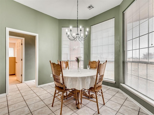 dining area with light tile patterned floors and an inviting chandelier