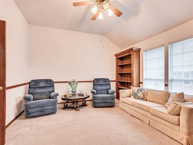 carpeted living room with ceiling fan and vaulted ceiling