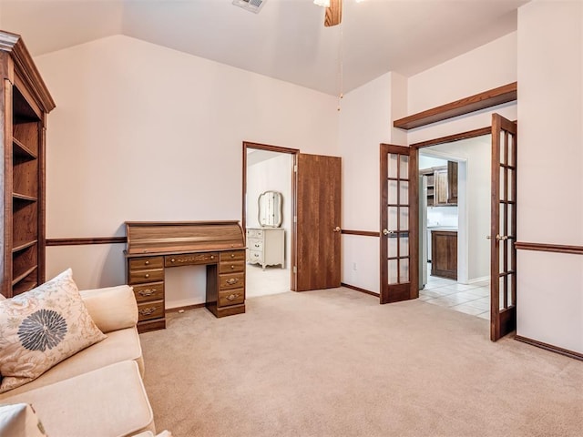 sitting room with ceiling fan, vaulted ceiling, light colored carpet, and french doors