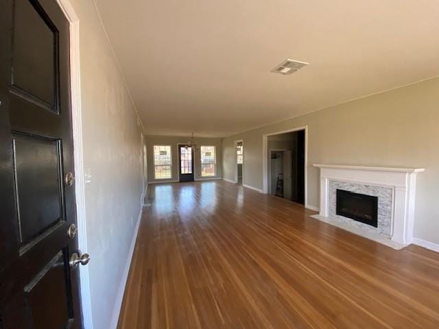 unfurnished living room with hardwood / wood-style flooring and a notable chandelier