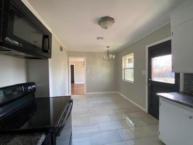 kitchen featuring white cabinetry, black appliances, decorative light fixtures, and a notable chandelier