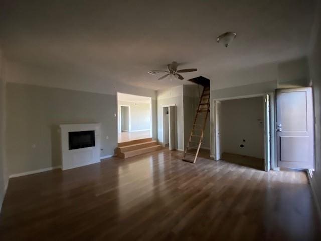 unfurnished living room with dark hardwood / wood-style floors and ceiling fan