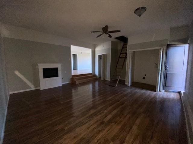 unfurnished living room featuring ceiling fan and dark hardwood / wood-style flooring