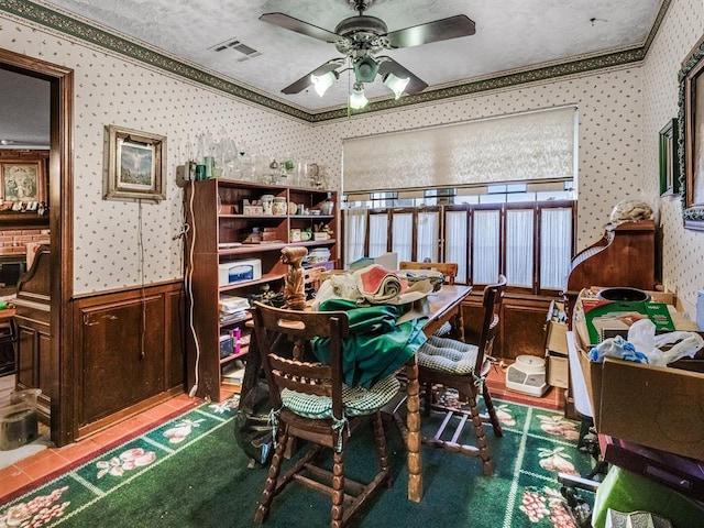 dining area featuring ceiling fan, crown molding, and a textured ceiling