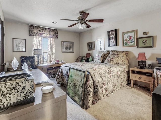 carpeted bedroom with ceiling fan and a textured ceiling