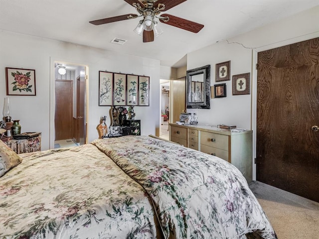 carpeted bedroom with ensuite bath and ceiling fan