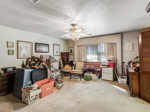 misc room featuring ceiling fan, light colored carpet, and a textured ceiling