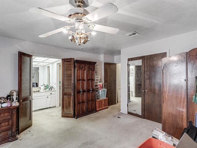 miscellaneous room with ceiling fan, light colored carpet, and a textured ceiling