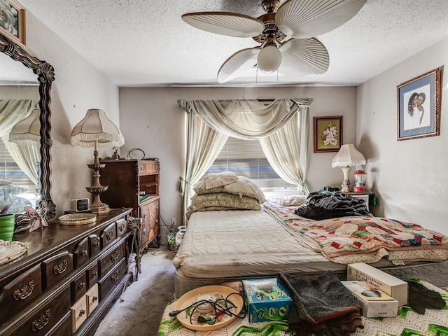 bedroom featuring ceiling fan, carpet, and a textured ceiling