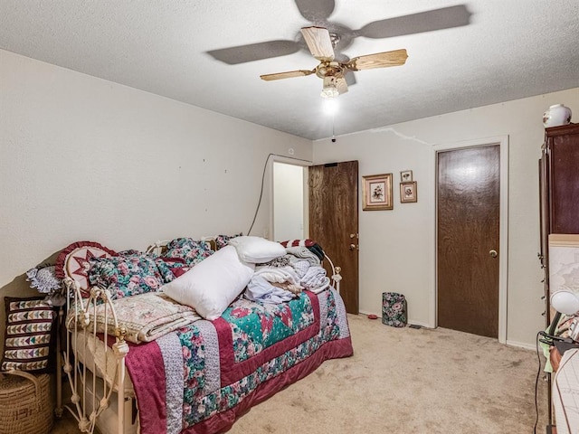 bedroom with carpet, ceiling fan, and a textured ceiling