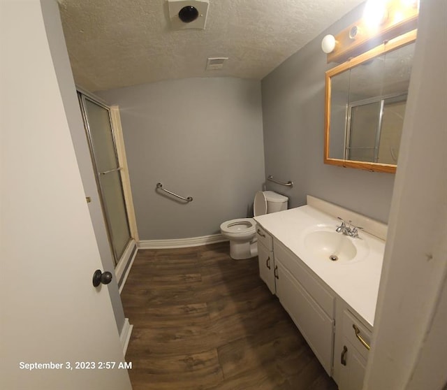 bathroom featuring walk in shower, a textured ceiling, toilet, vanity, and hardwood / wood-style flooring