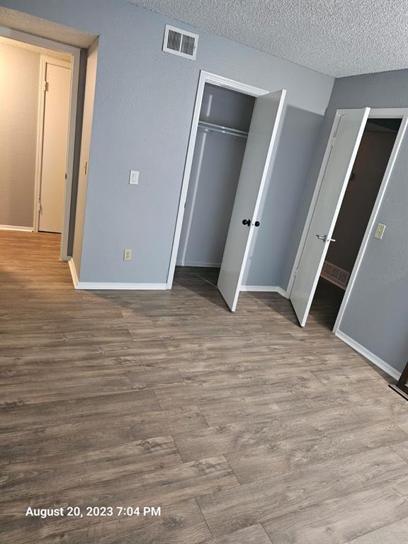 unfurnished bedroom featuring a textured ceiling and hardwood / wood-style flooring