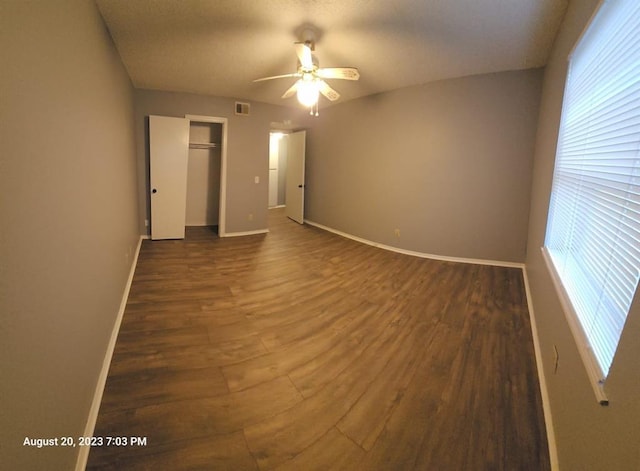 unfurnished bedroom with a closet, dark hardwood / wood-style floors, and ceiling fan