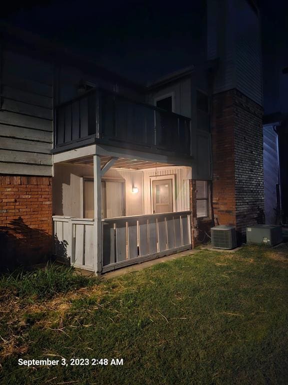 property exterior at twilight featuring a yard and central AC unit