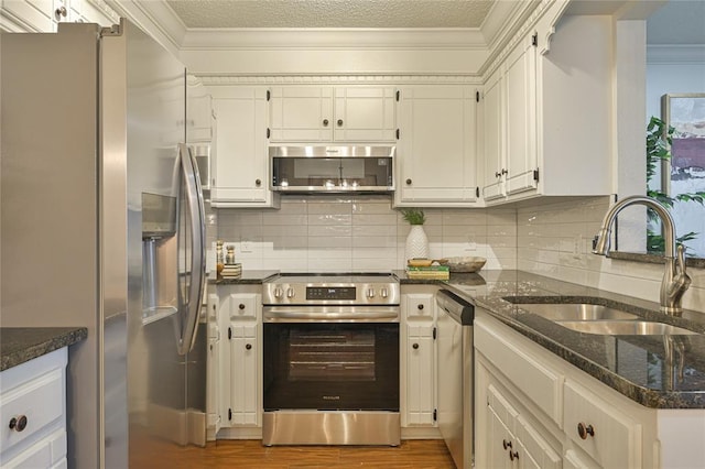 kitchen with white cabinets, backsplash, sink, and stainless steel appliances