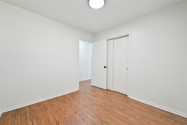 unfurnished bedroom featuring light hardwood / wood-style flooring and a closet