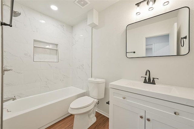 full bathroom featuring hardwood / wood-style flooring, vanity, toilet, and tiled shower / bath