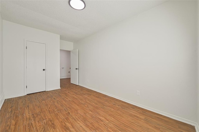 unfurnished bedroom with a textured ceiling and light wood-type flooring