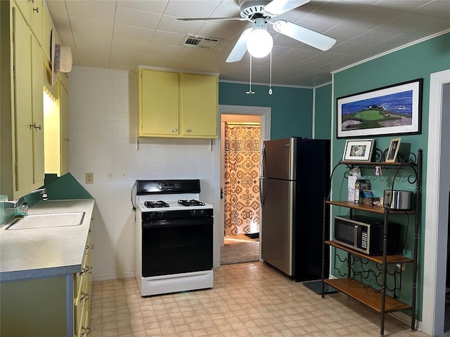 kitchen featuring ceiling fan, sink, white range, stainless steel fridge, and crown molding