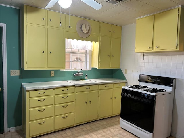 kitchen featuring ceiling fan, sink, decorative backsplash, and white gas range oven