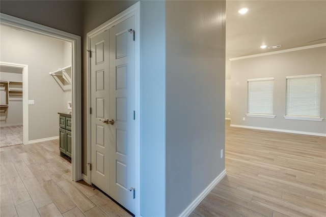 hallway featuring light hardwood / wood-style floors and crown molding