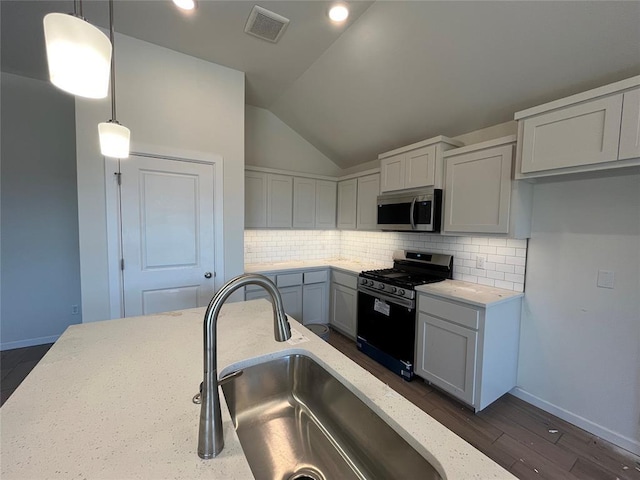 kitchen featuring decorative backsplash, a sink, visible vents, stainless steel appliances, and light stone countertops