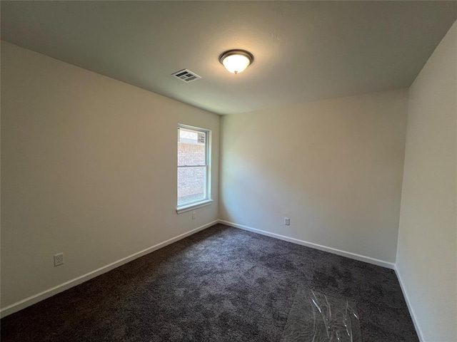 unfurnished room featuring baseboards, visible vents, and dark colored carpet