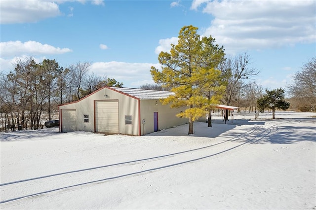 snow covered structure featuring a garage