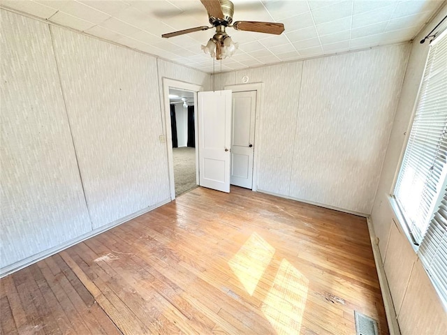 unfurnished room with hardwood / wood-style floors and ceiling fan