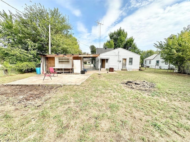 rear view of house featuring a patio area and a yard