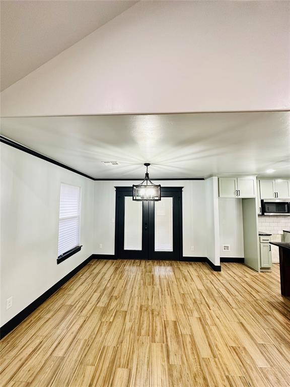 interior space with an inviting chandelier and light hardwood / wood-style flooring