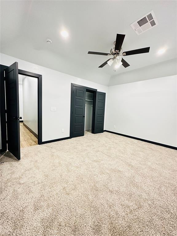 unfurnished bedroom featuring ceiling fan and light carpet