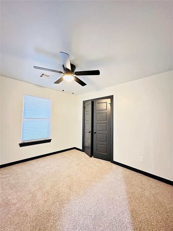 unfurnished bedroom with ceiling fan, carpet floors, and a closet