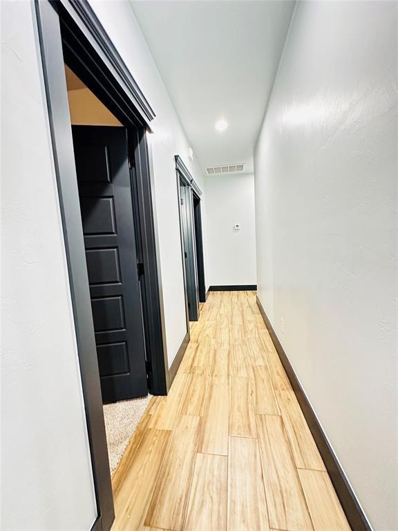 corridor with light wood-type flooring