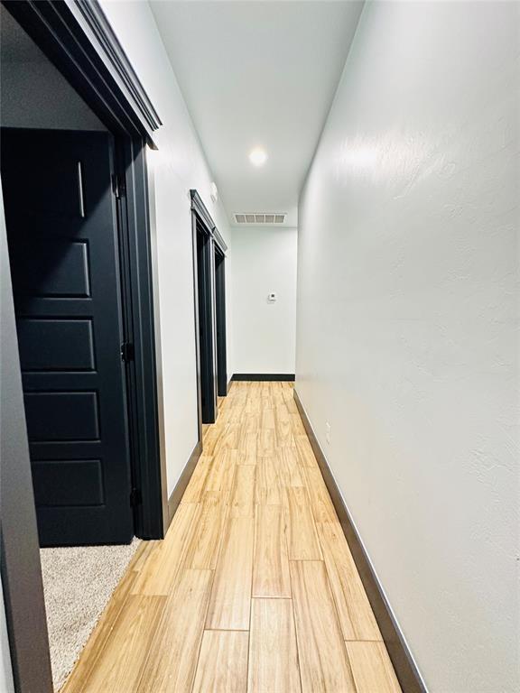 corridor with hardwood / wood-style floors