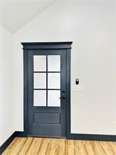 entryway featuring wood-type flooring and lofted ceiling