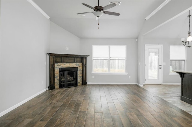 unfurnished living room featuring a fireplace, ceiling fan with notable chandelier, vaulted ceiling, and ornamental molding