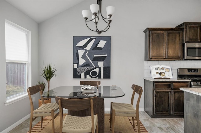 dining area featuring a chandelier and vaulted ceiling