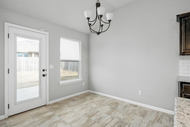 unfurnished dining area featuring a chandelier