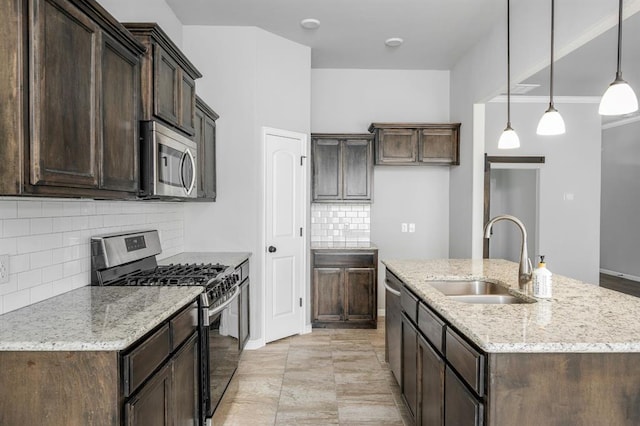 kitchen featuring backsplash, hanging light fixtures, sink, appliances with stainless steel finishes, and light stone counters