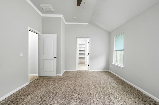 unfurnished bedroom with carpet flooring, ceiling fan, vaulted ceiling, a walk in closet, and a closet