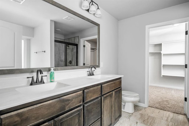 bathroom featuring toilet, vanity, and walk in shower