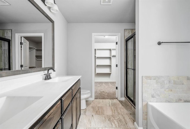 full bathroom featuring toilet, vanity, and separate shower and tub