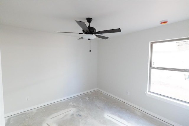 empty room featuring unfinished concrete floors, baseboards, and ceiling fan