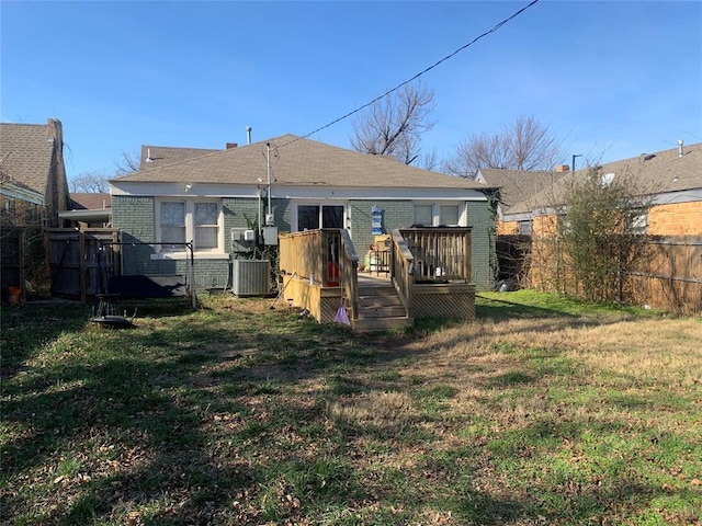 back of property with central air condition unit, a wooden deck, and a yard