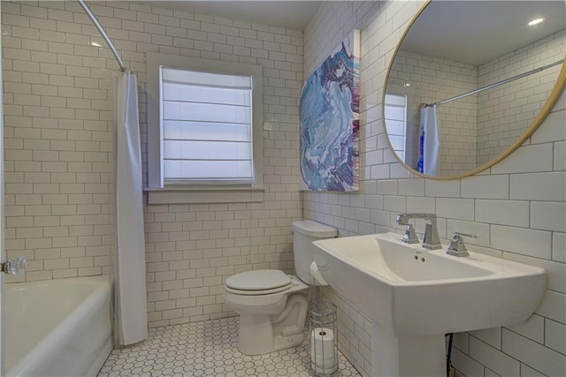 full bathroom with sink, tile patterned floors, shower / bath combination with curtain, toilet, and tile walls