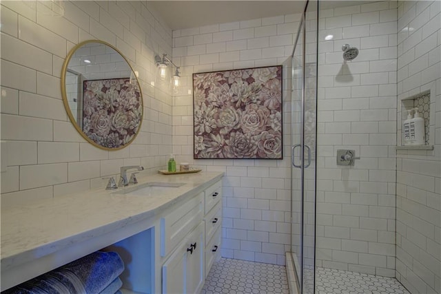 bathroom with vanity, tile patterned floors, tile walls, and a shower with shower door