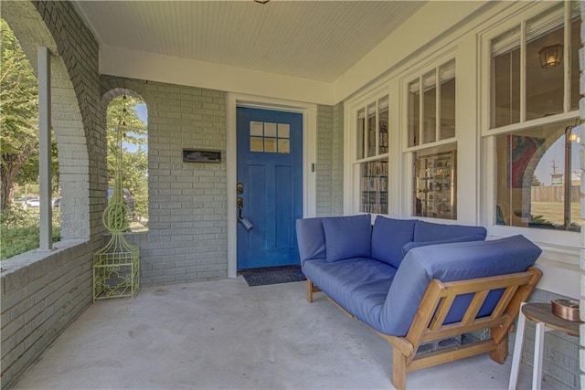 entrance to property featuring a porch and an outdoor hangout area