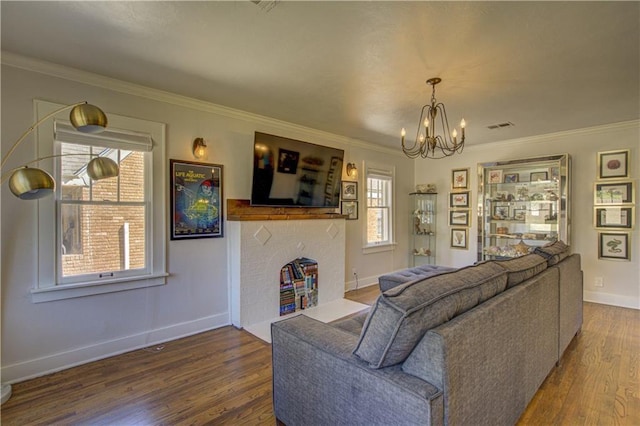 living room featuring crown molding, wood-type flooring, and a notable chandelier