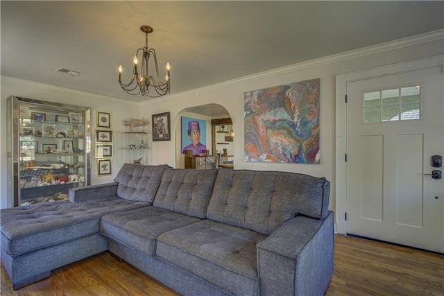 living room featuring hardwood / wood-style floors, ornamental molding, and an inviting chandelier